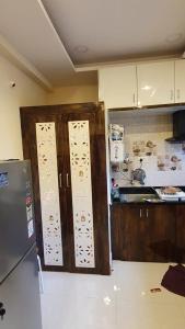 a kitchen with wooden cabinets and a refrigerator at skhanda family stay in Maula Ali