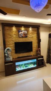 a flat screen tv on a wall with a fish tank at skhanda family stay in Maula Ali