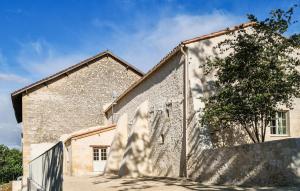 an old stone building with a tree next to it at Lovely Home In Les Leves Et Thoumeyra in Les Lèves-et-Thoumeyragues +36 photos