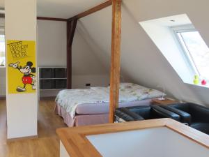 ein kleines Schlafzimmer im Dachgeschoss mit einem Bett und einer Couch in der Unterkunft Wohlfühlen in Bad Ems in Bad Ems