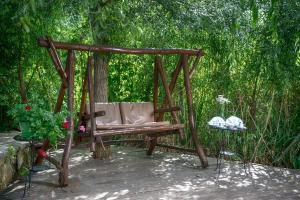 a wooden swing sitting on a patio with a table at Wineport Lodge Agva Riverside Hotel & Winery in Ağva