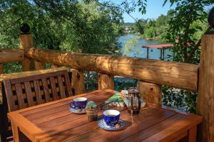 a wooden table with cups and saucers on a deck at Wineport Lodge Agva Riverside Hotel & Winery in Ağva
