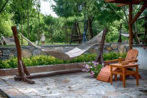 a hammock and a chair and a table in a garden at Wineport Lodge Agva Riverside Hotel & Winery in Ağva