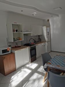 a small kitchen with white cabinets and a table and a table and a tableablish at Herman Pokoje - nr 4 in Hermanowice +4 photos