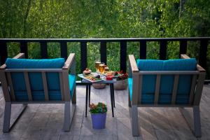 two chairs and a table with food on a patio at Wineport Lodge Agva Riverside Hotel & Winery in Ağva
