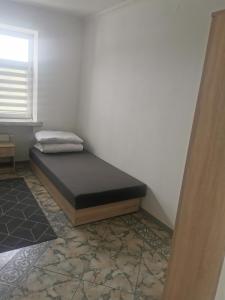 a bed sitting in a corner of a room at Herman Pokoje - nr 4 in Hermanowice