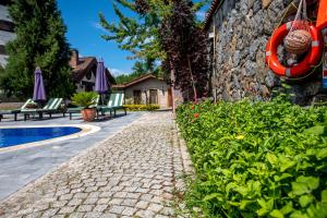 a stone path next to a house with a swimming pool at Wineport Lodge Agva Riverside Hotel & Winery in Ağva