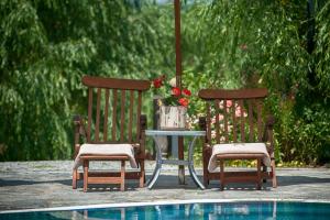 two chairs and a table next to a pool at Wineport Lodge Agva Riverside Hotel & Winery in Ağva