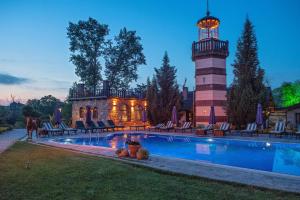 a house with a lighthouse next to a pool at Wineport Lodge Agva Riverside Hotel & Winery in Ağva