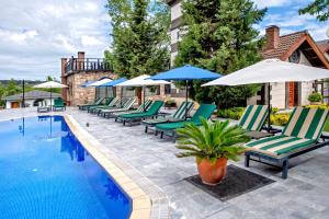a row of chairs and umbrellas next to a swimming pool at Wineport Lodge Agva Riverside Hotel & Winery in Ağva