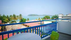 einen Balkon mit einem Tisch und Blick auf das Wasser in der Unterkunft Royal Agate Beach Resort in Pantai Cenang
