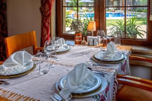 a dining room table with plates and glasses on it at Wineport Lodge Agva Riverside Hotel & Winery in Ağva