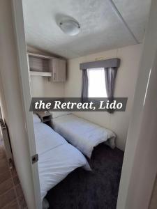 Un dormitorio con dos camas y un cartel que dice "El retiro" en The Retreat Lido Beach - Lido Beach Prestatyn, en Prestatyn 13 fotos más