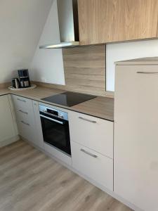 een keuken met witte kasten en een kookplaat oven bij La Clé des vignes 2 in Ribeauvillé +3 foto's