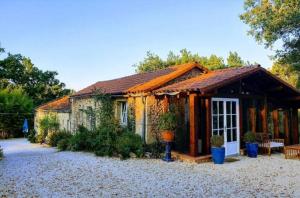 a small stone house with a roof at Gites nature 14 pers - 7 Ch - Piscine - Dordogne Lot in Montcabrier