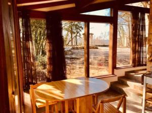 a table and chairs in a room with a window at Gites nature 14 pers - 7 Ch - Piscine - Dordogne Lot in Montcabrier