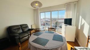 a living room with a couch and a table and a chair at Le Centre Bourg, situation rêvée in Saint-Jean-de-Monts