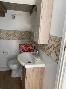 a small bathroom with a toilet and a sink at Casa Milona in Castelveccana