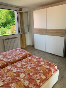 a bedroom with two beds and a large window at Casa Milona in Castelveccana +9 photos