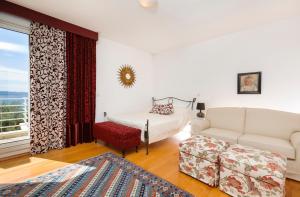 ein Schlafzimmer mit einem Bett und einer Couch und einem Fenster in der Unterkunft Apartment Oliva allegra in Split