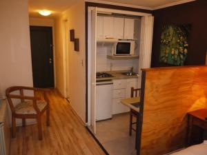 uma cozinha com uma mesa e um micro-ondas num quarto em Encomenderos Suites - Apartamentos Amoblados em Santiago