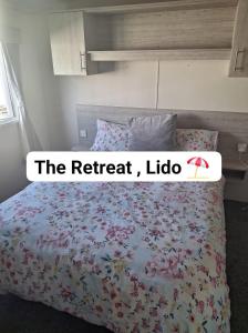 Un dormitorio con una cama con flores. en The Retreat Lido Beach - Lido Beach Prestatyn, en Prestatyn