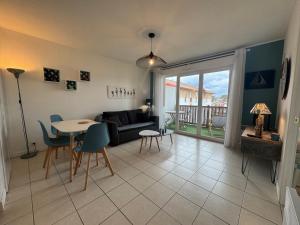 a living room with a couch and a table at Charmant T2 rénové avec terrasse proche plage - FR-1-239-1106 in Ciboure