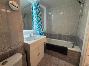 a bathroom with a sink and a tub and a toilet at Charmant T2 rénové avec terrasse proche plage - FR-1-239-1106 in Ciboure +4 photos