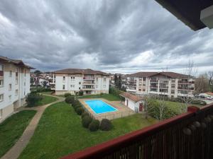 a view from a balcony of an apartment complex with a swimming pool at Charmant T2 rénové avec terrasse proche plage - FR-1-239-1106 in Ciboure