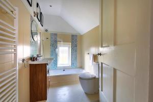 a bathroom with a sink and a toilet and a window at Finest Retreats - The Stables at Crimplesham in Stradsett
