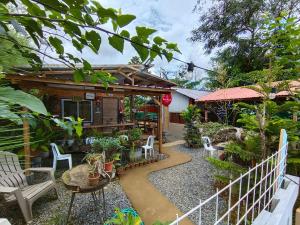 a garden with a house with a fence at Red's Cafè & Resto- Glass Cabin in Manolo Fortich