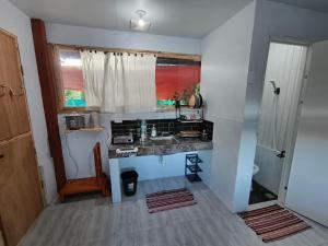 a small kitchen with a sink and a window at Red's Cafè & Resto- Glass Cabin in Manolo Fortich