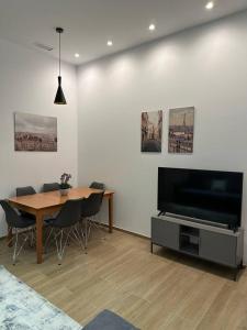 Una sala de estar con una mesa de comedor y un televisor. en Apartamento Murcia San José D, en Murcia
