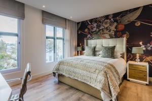 1 dormitorio con 1 cama grande y pared de flores en 107 Dorpstraat Boutique Hotel, en Stellenbosch