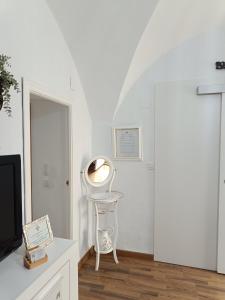 a white room with a chair and a mirror at Flor de Lis 1 in Cáceres