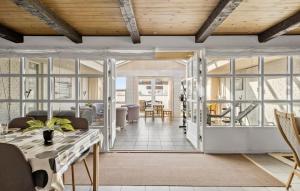 a living room with glass doors and a table at 5 Bedroom Nice Home In Blokhus in Blokhus