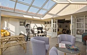 a conservatory with chairs and tables and a glass ceiling at 5 Bedroom Nice Home In Blokhus in Blokhus