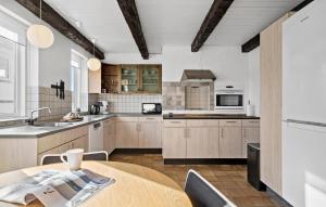 a kitchen with wooden cabinets and a wooden table at 5 Bedroom Nice Home In Blokhus in Blokhus