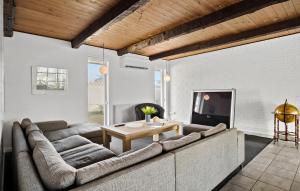 a living room with a couch and a table at 5 Bedroom Nice Home In Blokhus in Blokhus