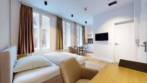 a hotel room with a bed and a table and window at Apartment 02 No 8A Boardinghouse Lüneburg in Lüneburg