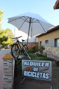una bicicleta estacionada en un cartel con un paraguas en Hotel Punto Sur Avenida, en Malargüe