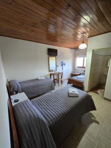 a bedroom with two beds and a living room at Hotel Punto Sur Avenida in Malargüe +21 photos