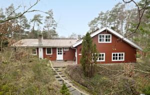 una casa rossa in mezzo a una foresta di 5 Bedroom Nice Home In Hadsund a Hadsund