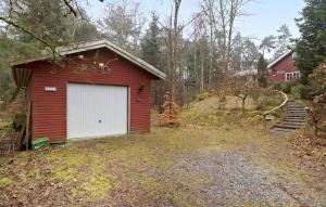 un garage rosso con una porta bianca in un cortile di 5 Bedroom Nice Home In Hadsund a Hadsund