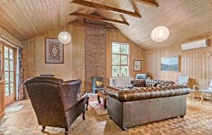 un soggiorno con divano in pelle e camino di 5 Bedroom Nice Home In Hadsund a Hadsund