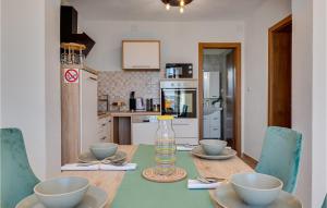 una cocina con una mesa con tazones y una botella de agua en Amazing Apartment In Baric Draga, en Barić Draga