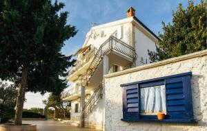 a white building with a blue door and a tree at Nice Apartment In Jezera With Wifi in Vrelo Koreničko