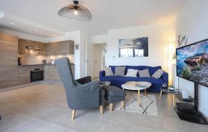 ein Wohnzimmer mit einem blauen Sofa und einem Tisch in der Unterkunft 3 Bedroom Cozy Apartment In Saint-Malo in Saint-Malo