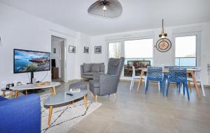 ein Wohnzimmer mit Sofa, Stühlen und einem Tisch in der Unterkunft 3 Bedroom Cozy Apartment In Saint-Malo in Saint-Malo