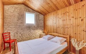 a bedroom with a bed and a red chair at Charmante Maison Proche Plage in Saint-Pierre-dʼOléron +18 photos